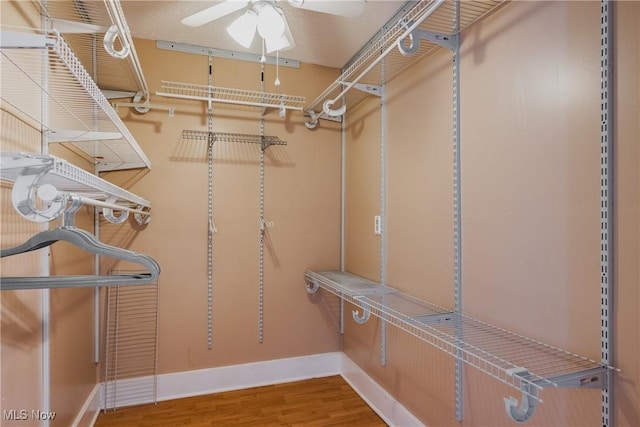 walk in closet with wood finished floors and ceiling fan