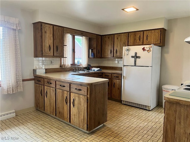 213 Kenmore Ave SE, Warren, OH 44483 - kitchen featuring freestanding refrigerator, decorative backsplash, a sink, and a peninsula