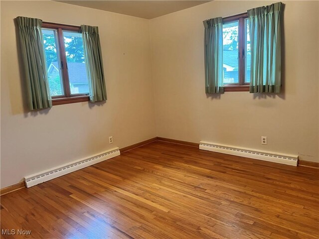 213 Kenmore Ave SE, Warren, OH 44483 - unfurnished room with a baseboard heating unit, hardwood / wood-style floors, and baseboards