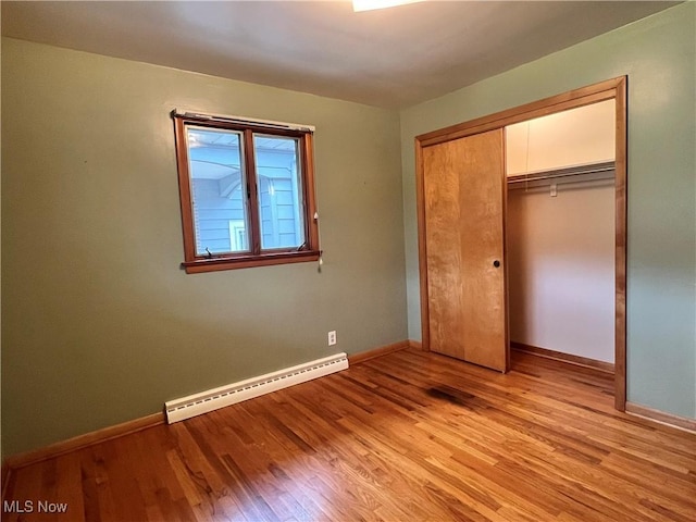 213 Kenmore Ave SE, Warren, OH 44483 - unfurnished bedroom with a baseboard heating unit, light wood finished floors, baseboards, and a closet