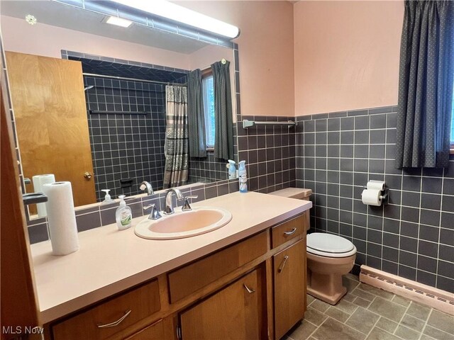 213 Kenmore Ave SE, Warren, OH 44483 - bathroom with a baseboard radiator, toilet, tile walls, vanity, and a tile shower