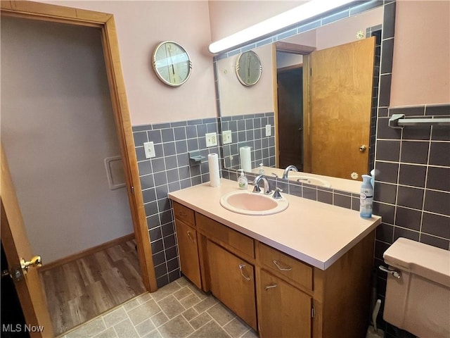 213 Kenmore Ave SE, Warren, OH 44483 - bathroom featuring tile walls, vanity, toilet, and wainscoting