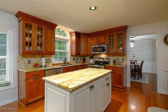 20686 Wildwood Ln, Strongsville, OH 44149 - kitchen featuring stainless steel appliances, light wood finished floors, glass insert cabinets, and backsplash