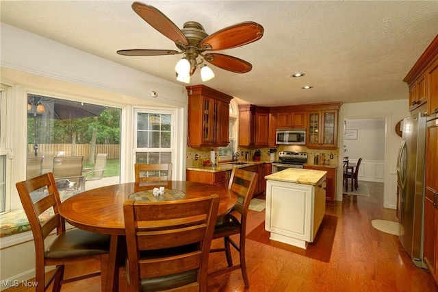 20686 Wildwood Ln, Strongsville, OH 44149 - dining area with dark wood finished floors, a ceiling fan, a textured ceiling, recessed lighting, and a wainscoted wall