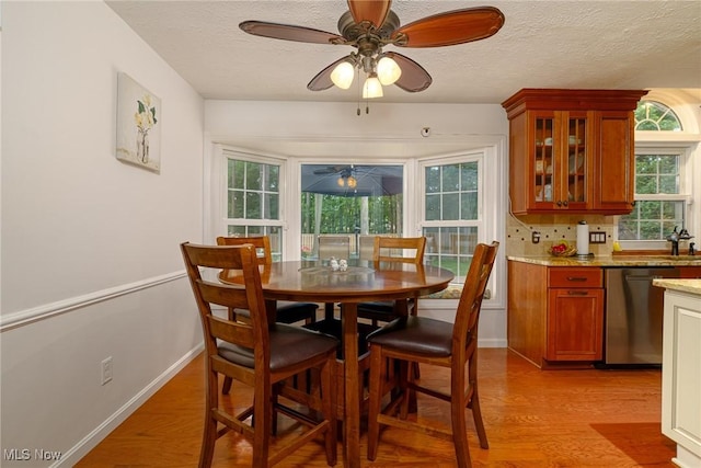 20686 Wildwood Ln, Strongsville, OH 44149 - dining room featuring ceiling fan, light wood-type flooring, a textured ceiling, and baseboards