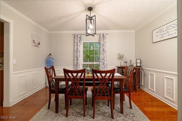 20686 Wildwood Ln, Strongsville, OH 44149 - dining area with wood finished floors, a textured ceiling, ornamental molding, and wainscoting