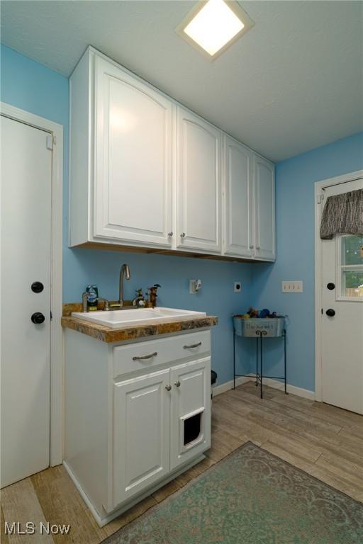 20686 Wildwood Ln, Strongsville, OH 44149 - washroom with cabinet space, light wood-style floors, hookup for a washing machine, and baseboards