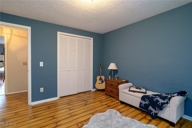 20686 Wildwood Ln, Strongsville, OH 44149 - bedroom with hardwood / wood-style flooring, a closet, baseboards, and a textured ceiling