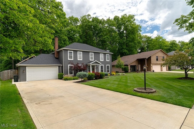 20686 Wildwood Ln, Strongsville, OH 44149 - colonial-style house featuring a chimney, a front yard, driveway, and an attached garage