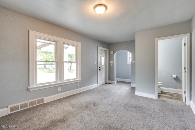 1866 17th St SW, Akron, OH 44314 - foyer entrance with arched walkways, carpet, baseboards, and a textured wall