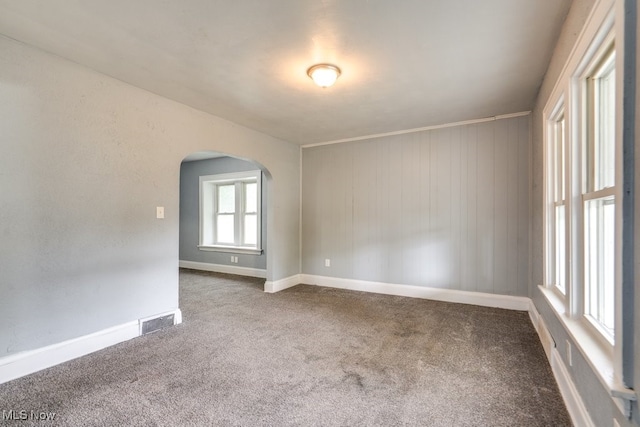 1866 17th St SW, Akron, OH 44314 - spare room featuring arched walkways, carpet, and baseboards