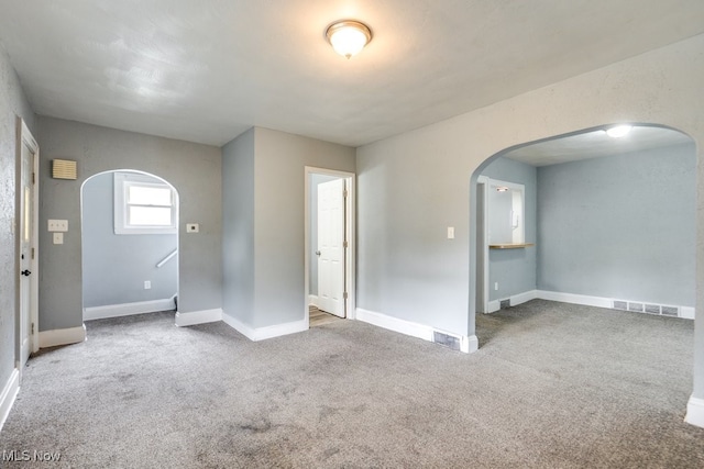1866 17th St SW, Akron, OH 44314 - spare room featuring arched walkways, carpet, and baseboards