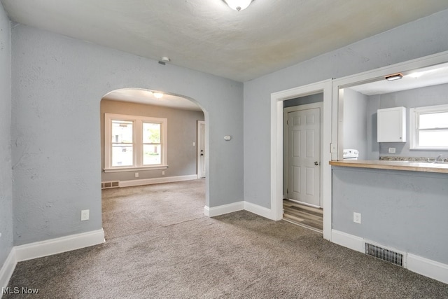 1866 17th St SW, Akron, OH 44314 - empty room with arched walkways, carpet, and baseboards