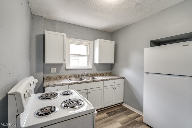 1866 17th St SW, Akron, OH 44314 - kitchen featuring white appliances, a sink, white cabinets, light wood-type flooring, and a textured ceiling