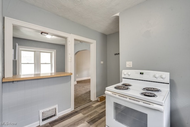 1866 17th St SW, Akron, OH 44314 - kitchen with white range with electric cooktop, wood finished floors, a textured ceiling, and baseboards