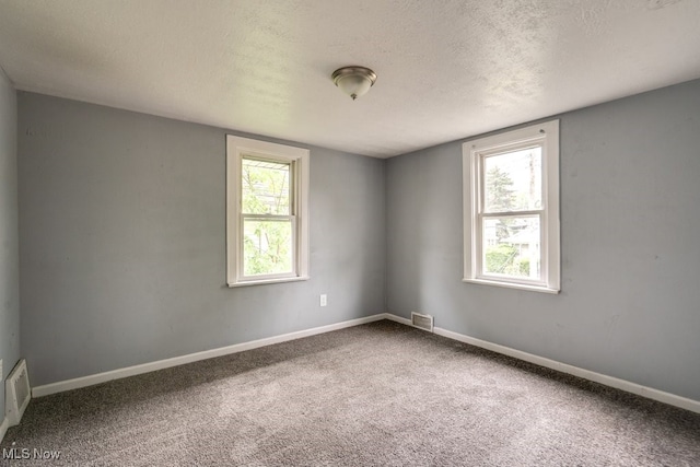 1866 17th St SW, Akron, OH 44314 - carpeted empty room featuring a textured ceiling, plenty of natural light, and baseboards