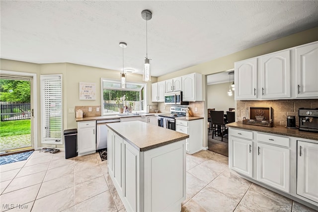 20393 Wildwood Ln, Strongsville, OH 44149 - kitchen with appliances with stainless steel finishes, backsplash, white cabinetry, plenty of natural light, and a textured ceiling