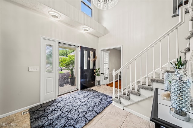 20393 Wildwood Ln, Strongsville, OH 44149 - foyer with a high ceiling, stairs, baseboards, and a chandelier