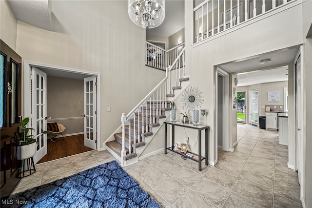 20393 Wildwood Ln, Strongsville, OH 44149 - entryway featuring stairs, a high ceiling, french doors, a chandelier, and baseboards