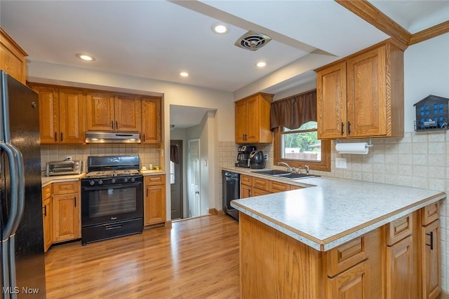 6351 W 130th St, Parma Heights, OH 44130 - kitchen featuring black appliances, under cabinet range hood, a sink, light countertops, and light wood-type flooring