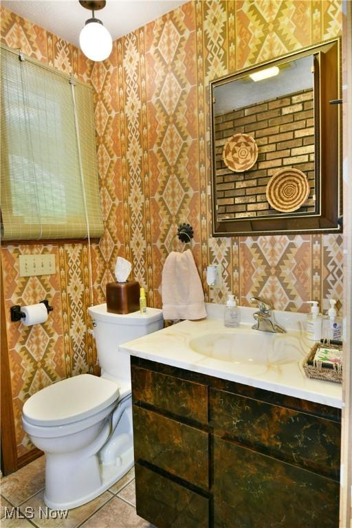 2942 Barclay Messerly Rd, Southington, OH 44470 - half bathroom with wallpapered walls, vanity, toilet, and tile patterned flooring