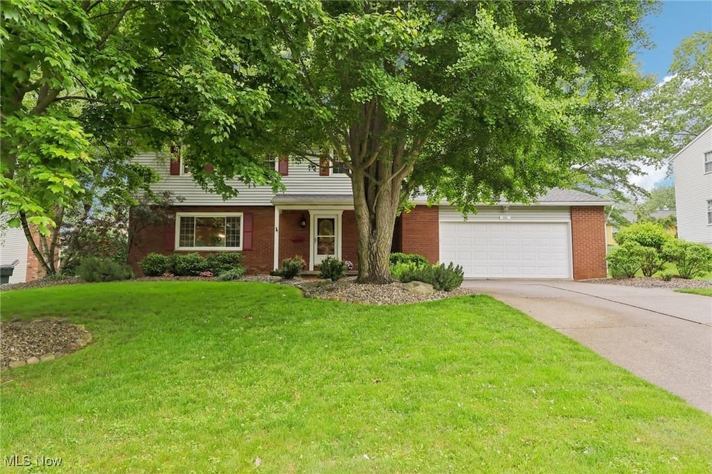 301 Windfall Ln, Wadsworth, OH 44281 - view of front facade featuring concrete driveway, a front yard, a garage, and brick siding