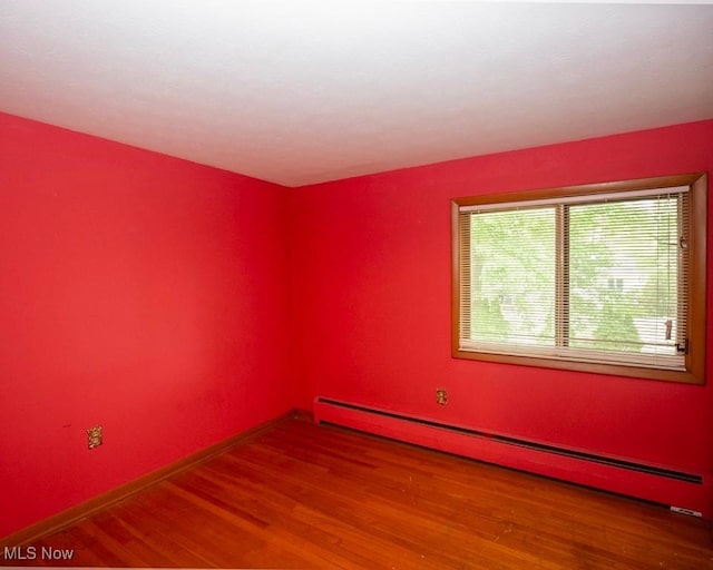 433 University Ave, Elyria, OH 44035 - spare room featuring a baseboard radiator, wood finished floors, and baseboards