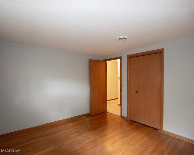 433 University Ave, Elyria, OH 44035 - unfurnished bedroom featuring light wood-type flooring, a closet, and baseboards