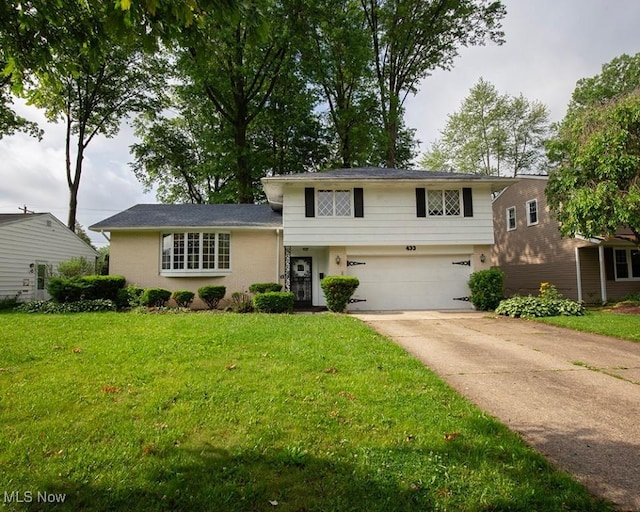 433 University Ave, Elyria, OH 44035 - split level home with an attached garage, driveway, a front lawn, and stucco siding