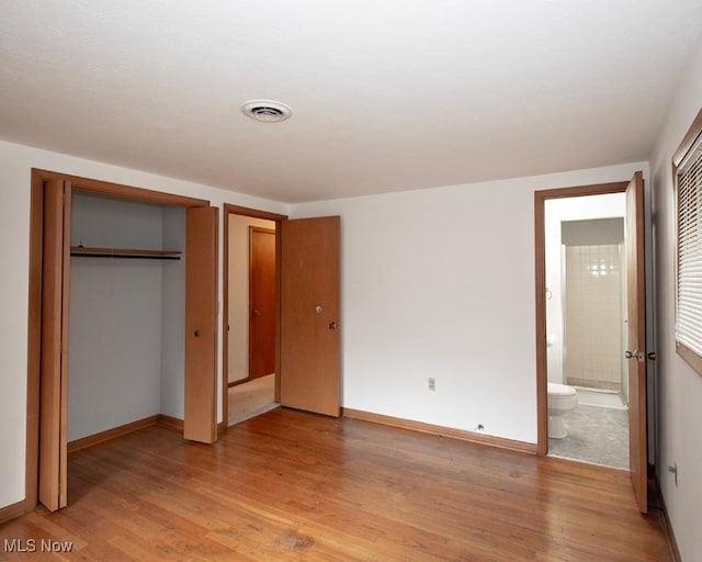 433 University Ave, Elyria, OH 44035 - unfurnished bedroom with light wood-type flooring, baseboards, and connected bathroom