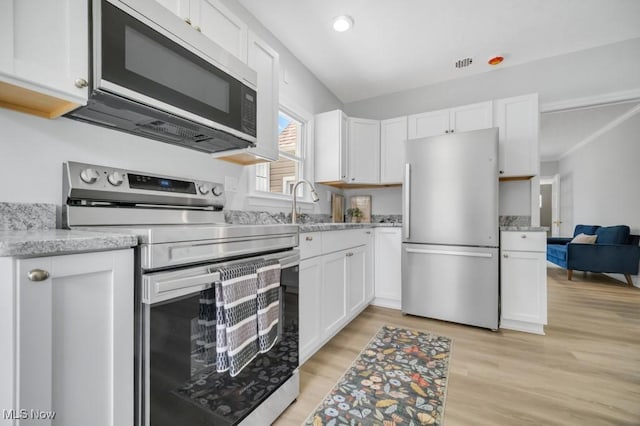 2186 Jackson Blvd, University Heights, OH 44118 - kitchen featuring stainless steel appliances, white cabinetry, light wood finished floors, light stone counters, and recessed lighting