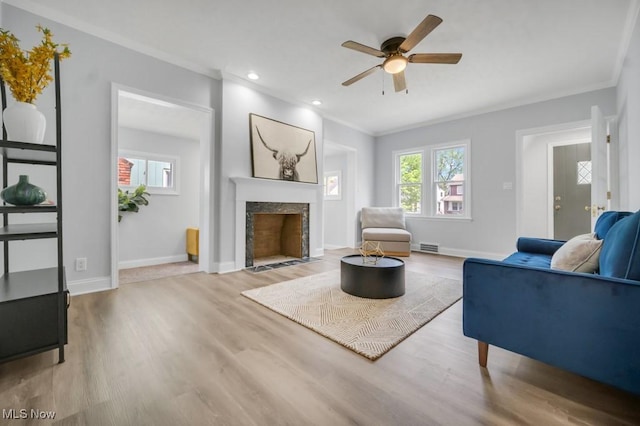 2186 Jackson Blvd, University Heights, OH 44118 - living area featuring crown molding, a ceiling fan, light wood-type flooring, a premium fireplace, and baseboards