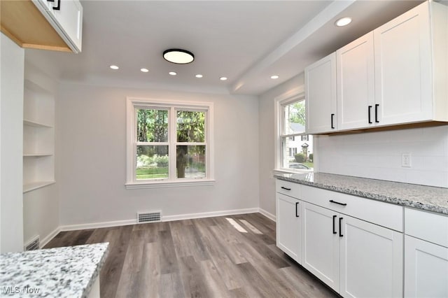 3890 Grosvenor Rd, South Euclid, OH 44118 - kitchen featuring recessed lighting, backsplash, light stone counters, white cabinets, and wood finished floors
