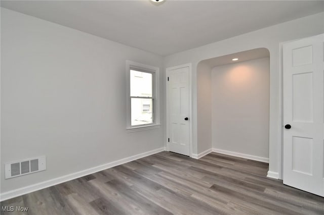 3890 Grosvenor Rd, South Euclid, OH 44118 - empty room with wood finished floors, baseboards, and arched walkways
