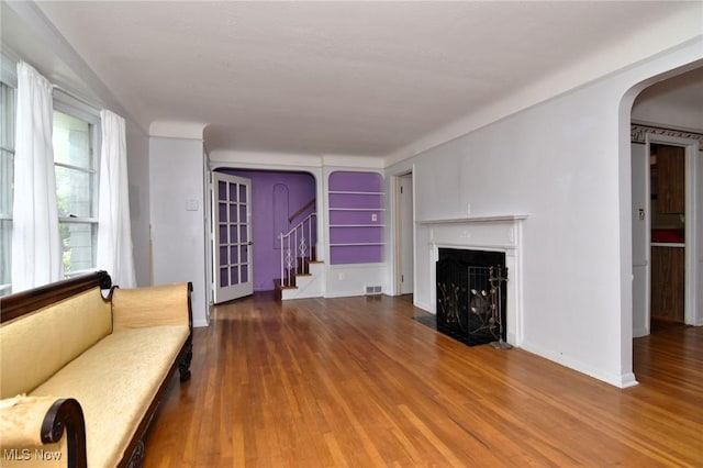 3927 Princeton Blvd, South Euclid, OH 44121 - living room featuring arched walkways, wood finished floors, baseboards, stairway, and a fireplace with flush hearth