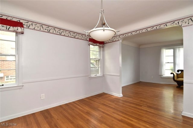 3927 Princeton Blvd, South Euclid, OH 44121 - empty room featuring healthy amount of natural light, wood finished floors, arched walkways, and baseboards