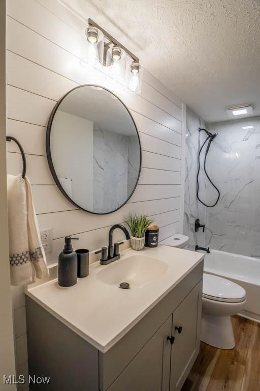 432 Celia Ave, Akron, OH 44312 - bathroom featuring vanity, a textured ceiling, wood finished floors, washtub / shower combination, and toilet