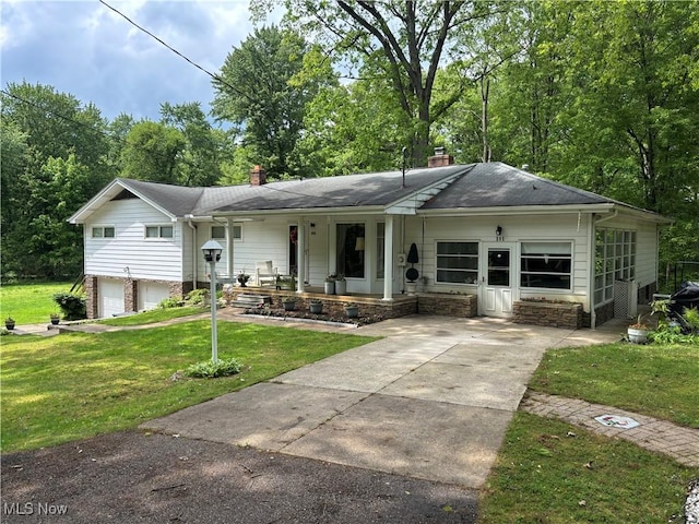505 Woodside St SW, Hartville, OH 44632 - view of front of house with a chimney, driveway, a porch, a front yard, and a garage