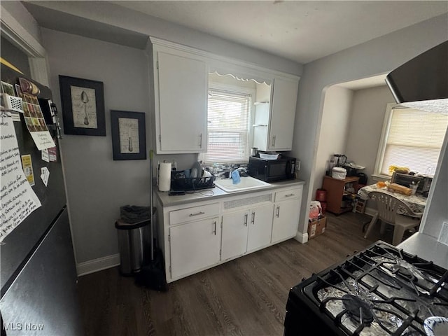 4241 Hinsdale Rd, South Euclid, OH 44121 - kitchen with a sink, light countertops, black appliances, dark wood-type flooring, and white cabinetry
