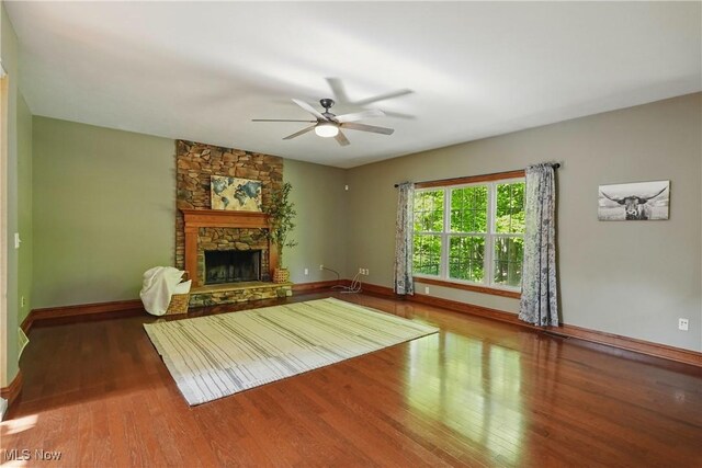 7234 Bridlewood Dr, Concord, OH 44077 - unfurnished living room with wood finished floors, baseboards, a ceiling fan, and a stone fireplace