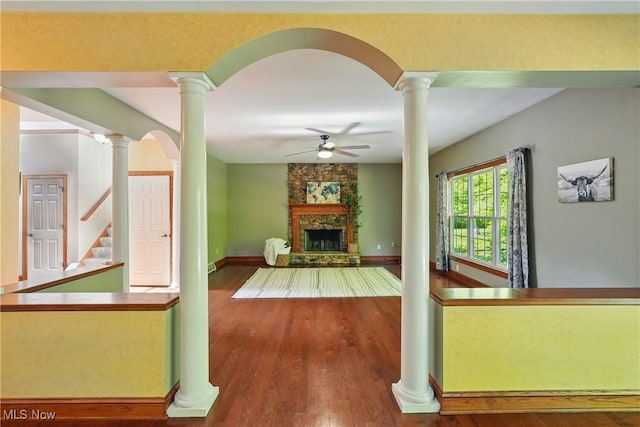 7234 Bridlewood Dr, Concord, OH 44077 - living room with a ceiling fan, a stone fireplace, wood finished floors, baseboards, and decorative columns