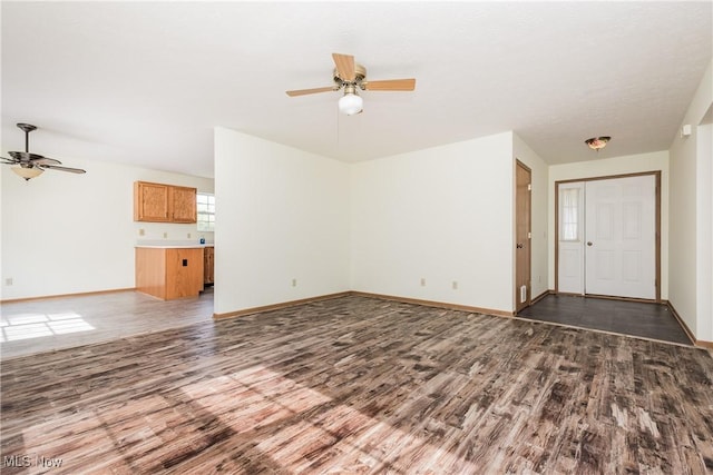 10237 Middlebranch Ave NE, Hartville, OH 44632 - unfurnished living room featuring a ceiling fan, wood finished floors, and baseboards