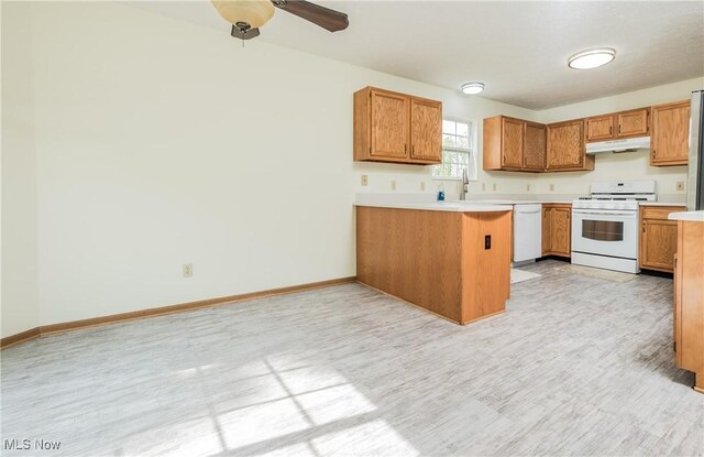 10237 Middlebranch Ave NE, Hartville, OH 44632 - kitchen featuring white appliances, under cabinet range hood, a peninsula, light countertops, and baseboards