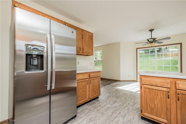 10237 Middlebranch Ave NE, Hartville, OH 44632 - kitchen with stainless steel fridge with ice dispenser, light wood-style flooring, ceiling fan, light countertops, and baseboards