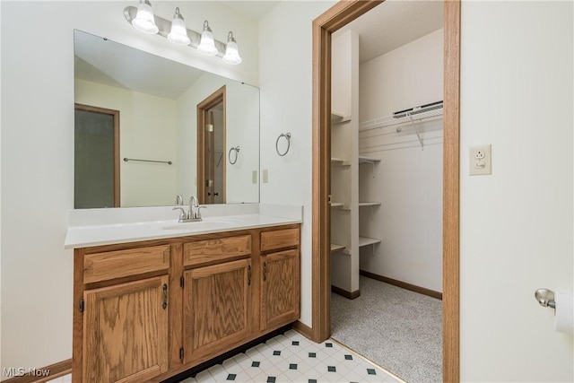 10237 Middlebranch Ave NE, Hartville, OH 44632 - bathroom with vanity, a walk in closet, and baseboards