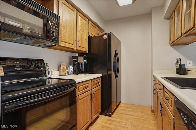 2426 Wrens Dr S, Stow, OH 44224 - kitchen featuring black appliances, light wood-style floors, light countertops, a sink, and brown cabinets