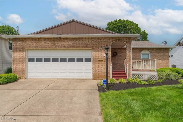401 9th St NW, North Canton, OH 44720 - view of front of property with brick siding, concrete driveway, a front yard, and an attached garage