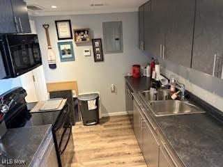 8452 E Bay Shore Rd Unit 7, Danbury, OH 43440 - kitchen featuring black appliances, a sink, baseboards, light wood finished floors, and electric panel