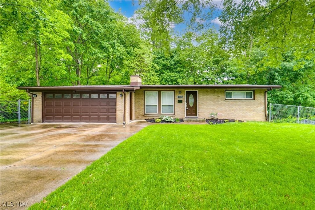 1635 Kingsley Ave, Akron, OH 44313 - view of front of property with an attached garage, a chimney, concrete driveway, and brick siding