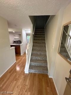 4757 Ledgewood Dr Unit 7-A, Medina, OH 44256 - stairs featuring a textured ceiling, baseboards, and wood finished floors
